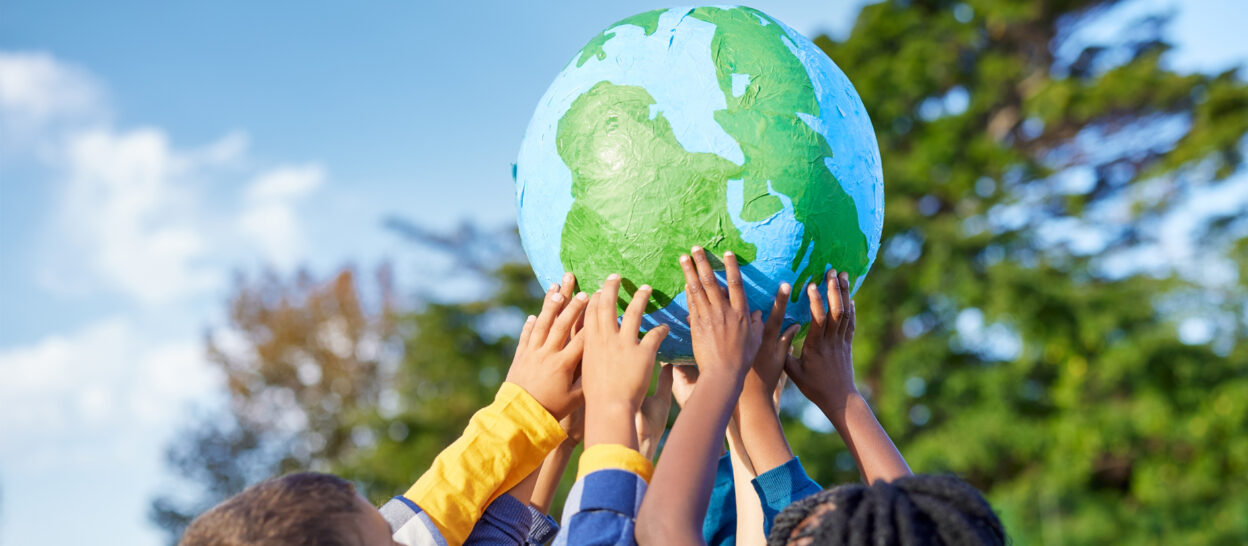 Kids holding up a paper globe